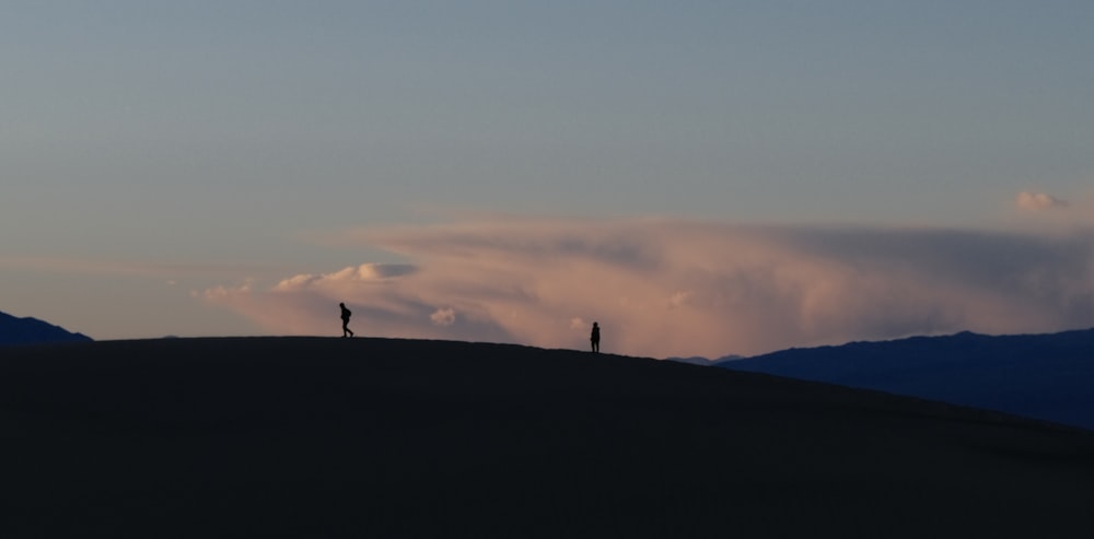 a couple of people standing on top of a hill