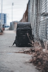 A stylish backpack resting against a city sidewalk, ready for a busy day.