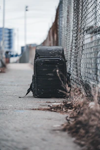 A stylish backpack casually placed on a city sidewalk with blurred urban background.