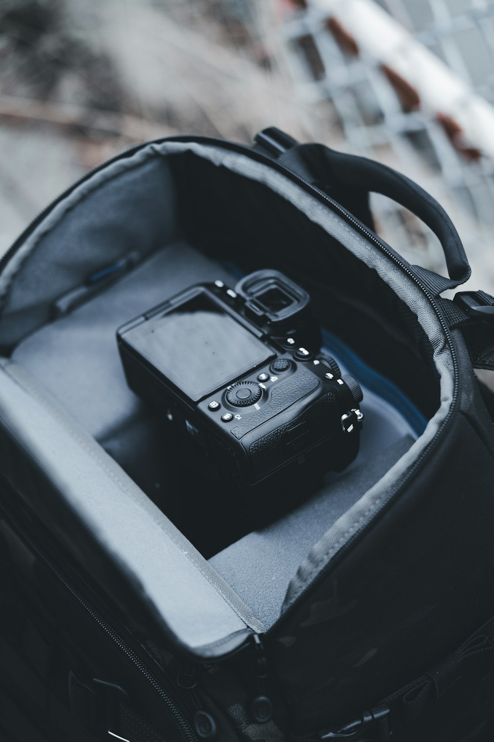 a camera sitting inside of a black backpack