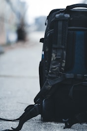 a back pack sitting on the ground on a sidewalk