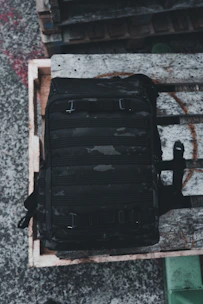 Display of tactical backpacks and gear arranged neatly against a dark background.