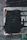 Close-up of a black tactical bag with multiple compartments, set against a dark urban backdrop.