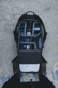 An open backpack with shoes packed inside a kelvinp llc waterproof shoe organizer bag.