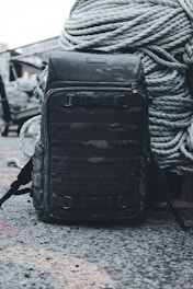 a backpack sitting on the ground next to a rope