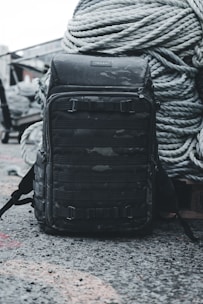 a backpack sitting on the ground next to a rope