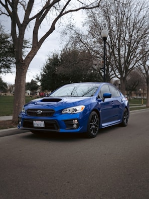Blue family sedan parked on a leafy suburban road in Glasgow.