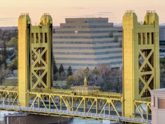 a yellow bridge with a building in the background