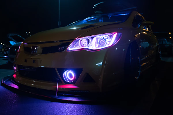 Bright decorative LED lights illuminating a car’s exterior at dusk, showcasing custom styling.