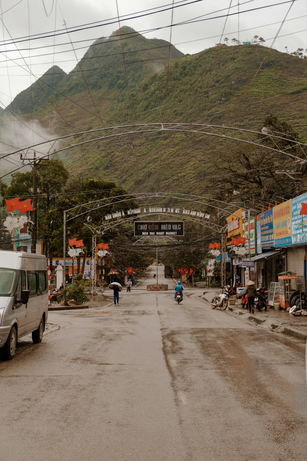 a van driving down a street next to a mountain