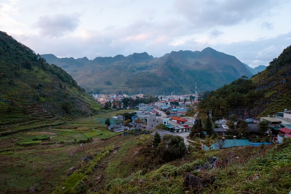 a small town nestled in a valley with mountains in the background