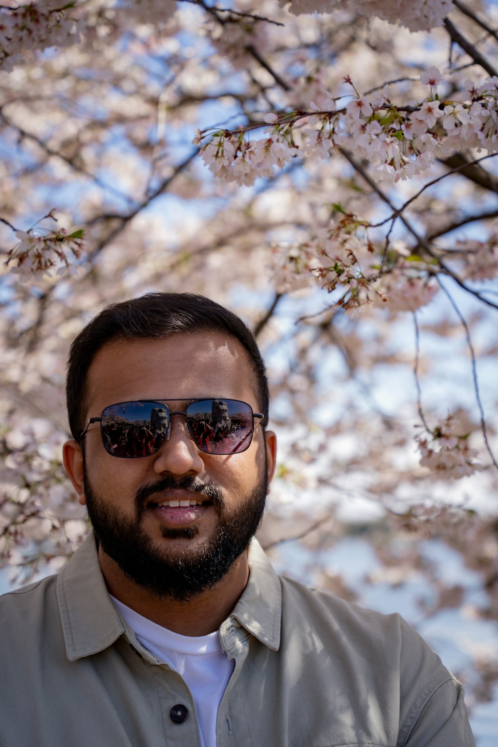 a man with a beard and sunglasses under a tree