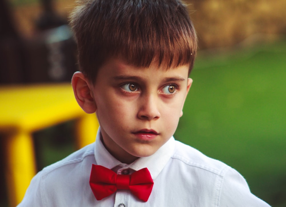 a young boy wearing a red bow tie