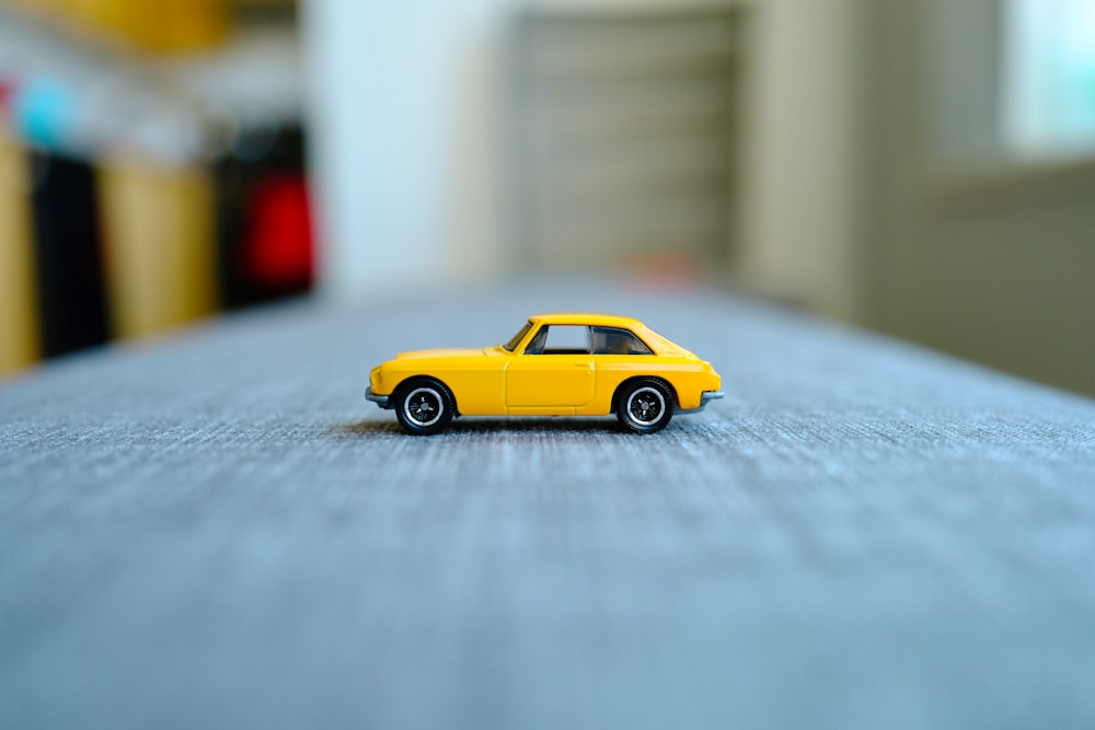 a yellow toy car sitting on top of a table