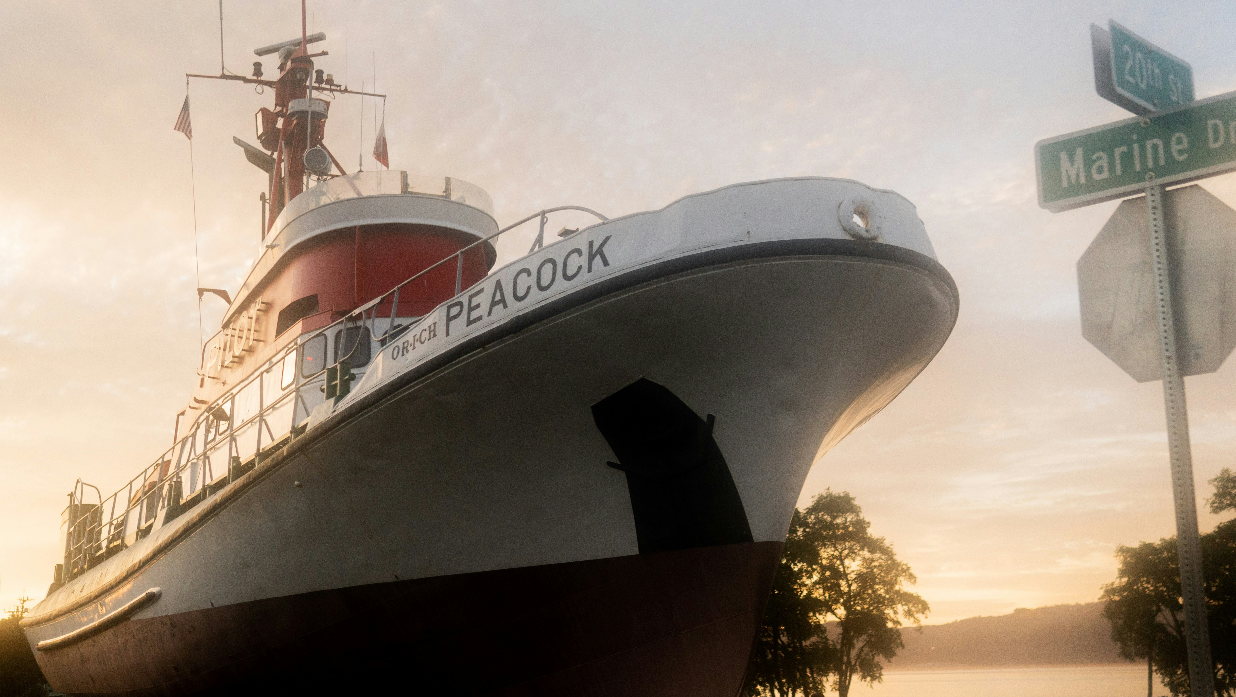 a large boat sitting next to a street sign