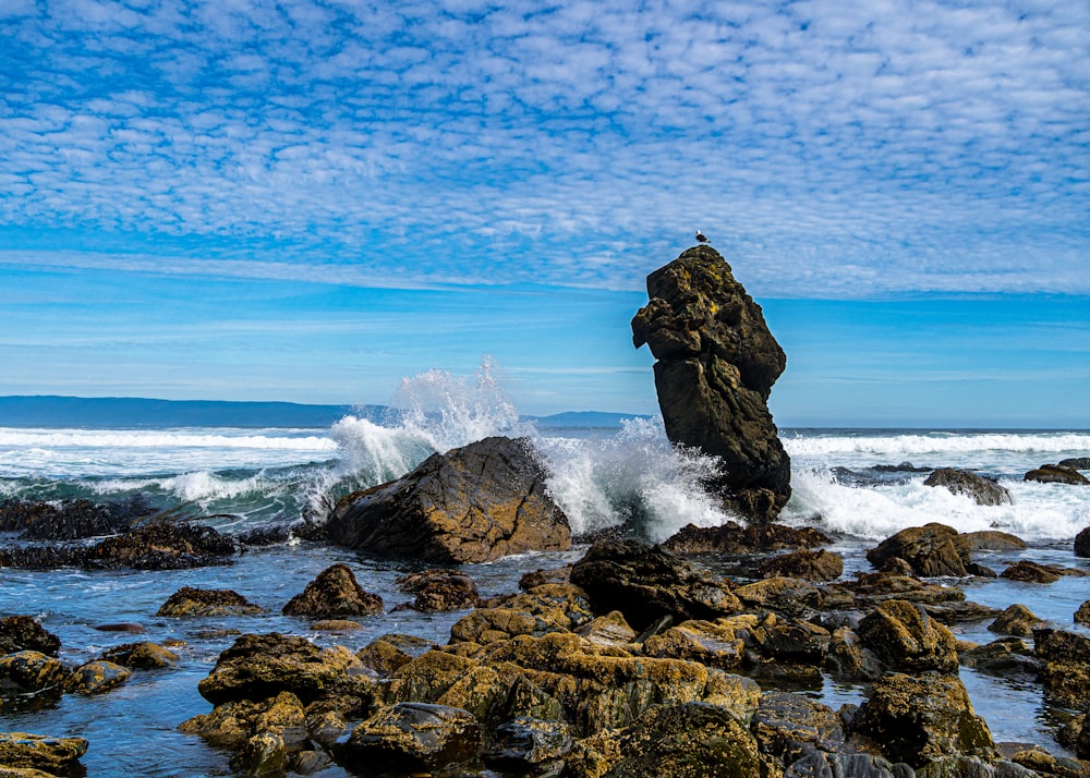 a large rock sticking out of the ocean