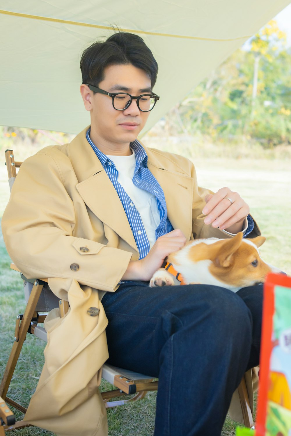 a man sitting in a chair holding a small dog
