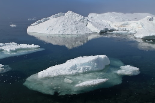 a group of icebergs floating on top of a body of water