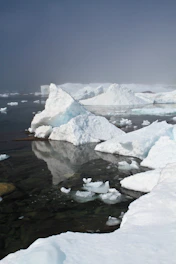 a group of icebergs floating on top of a body of water