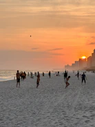A vibrant beach resort at sunset with travelers enjoying the view