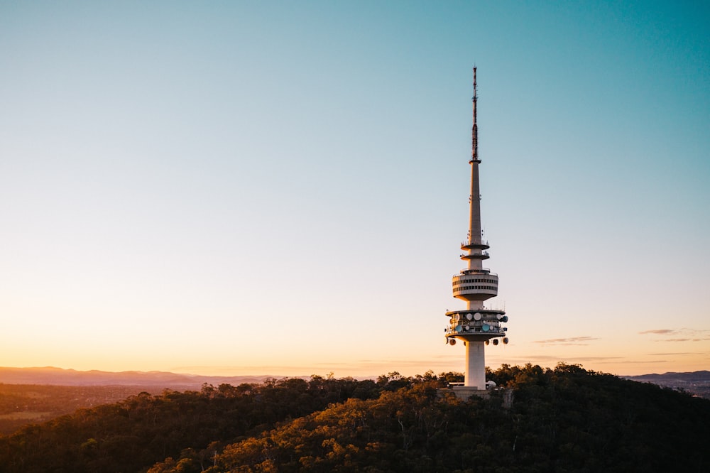 a very tall tower sitting on top of a lush green hillside