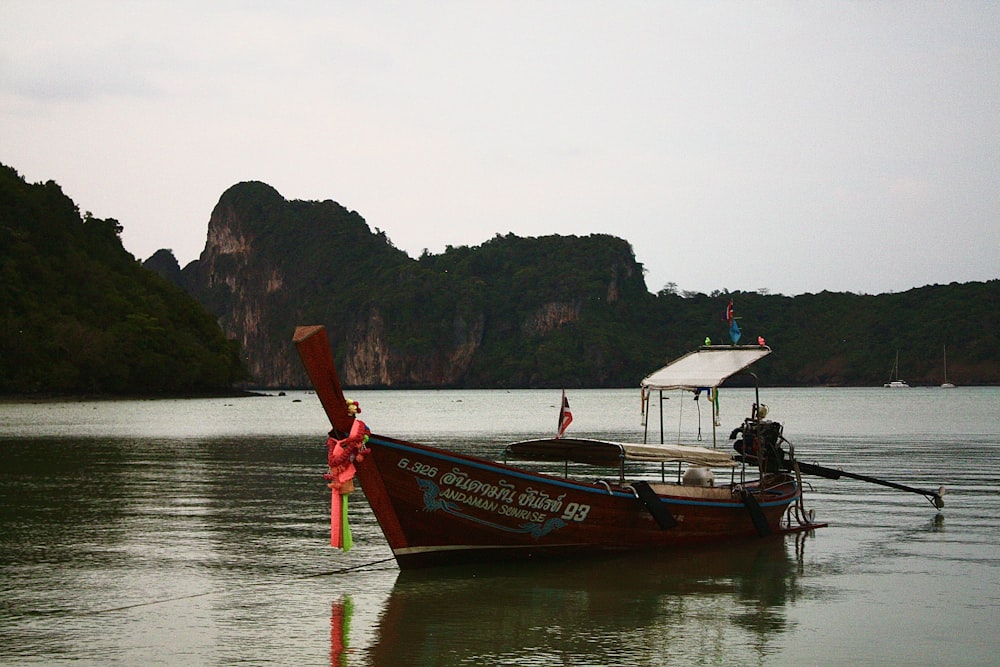 a long boat on a body of water with mountains in the background