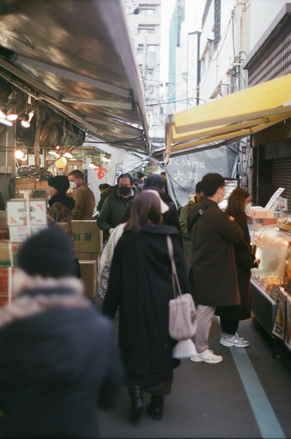 a group of people standing around a food stand