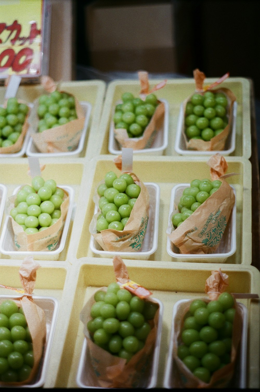 a table topped with trays filled with green grapes