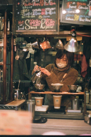 Barista carefully preparing coffee with traditional Chiapas methods in a vibrant café setting.