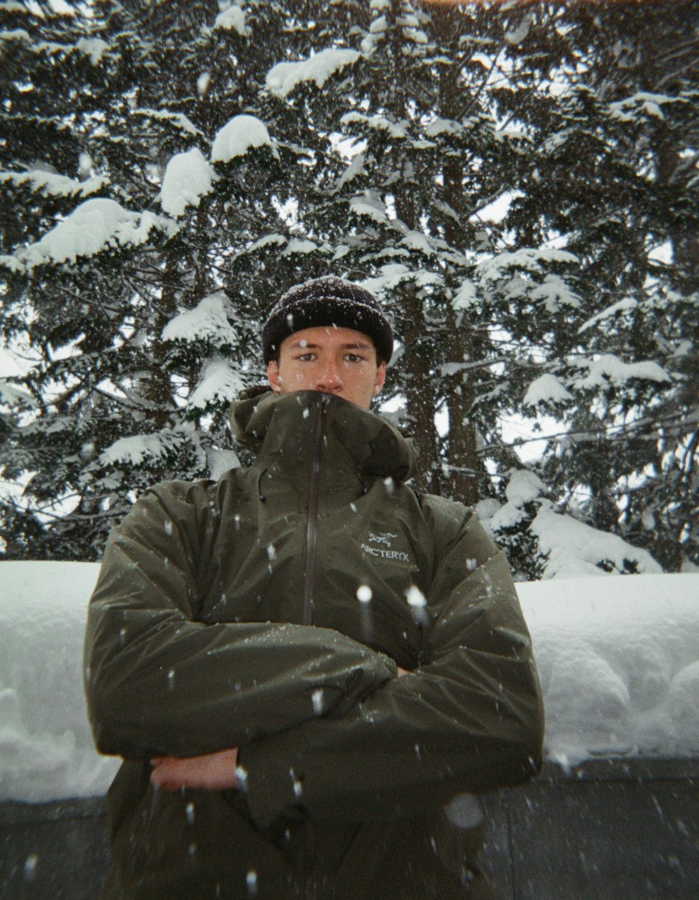 a man standing in front of snow covered trees