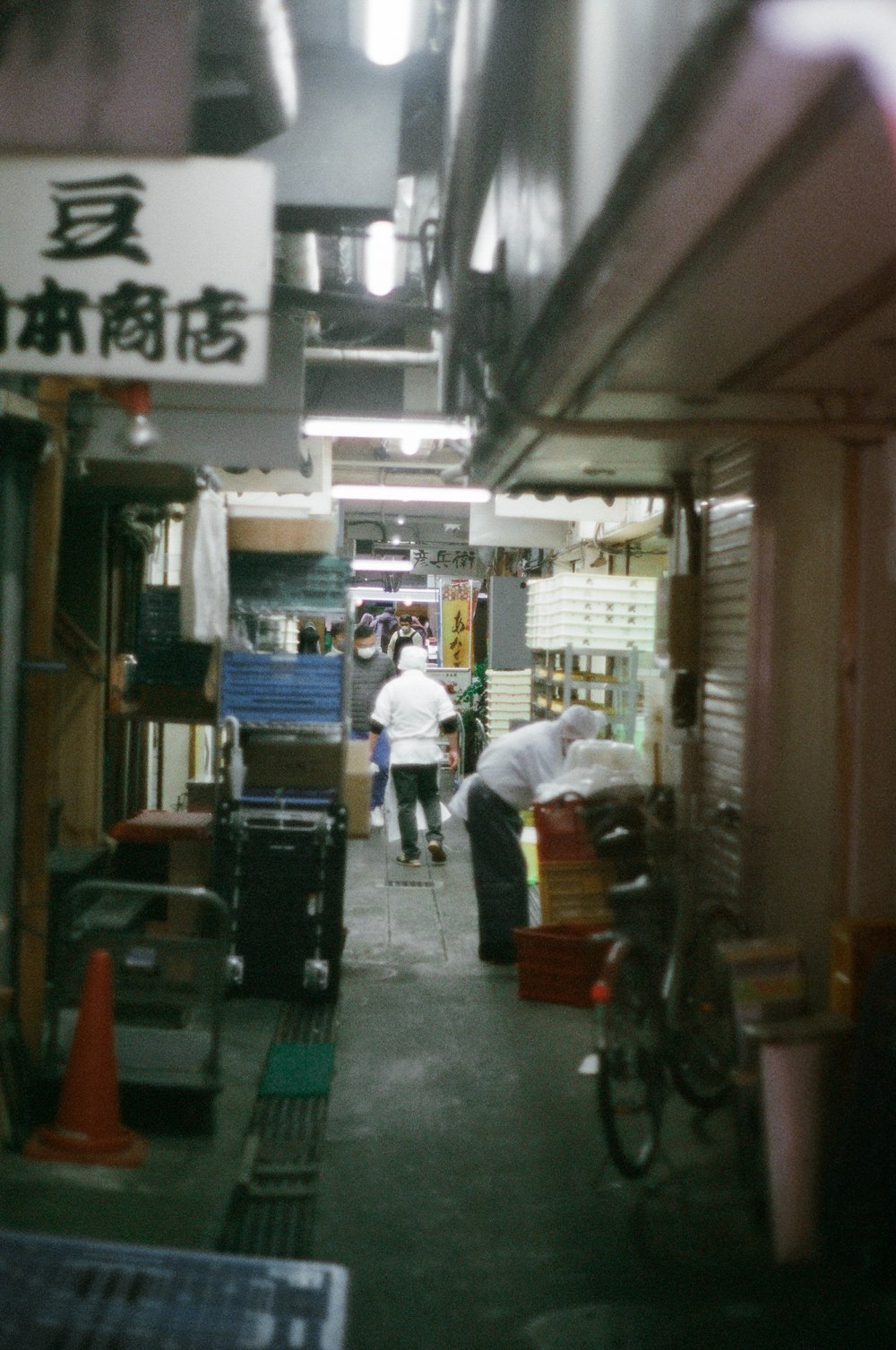 a group of people walking down a street next to a store