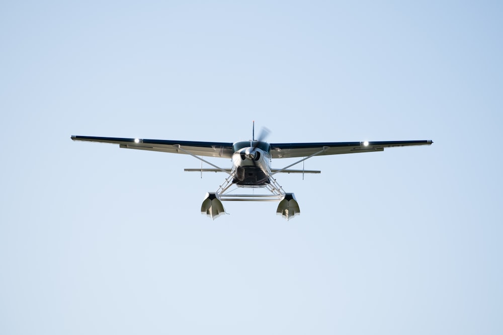 a small propeller plane flying through a blue sky