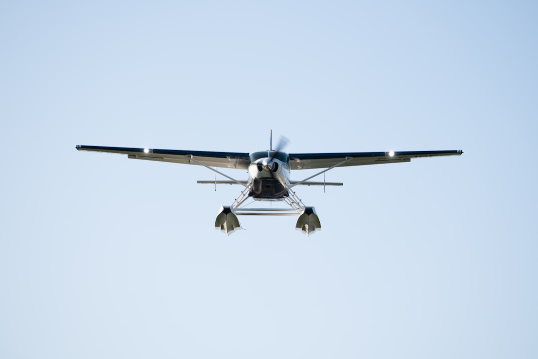 a small propeller plane flying through a blue sky, A Seaplane on Final Approach