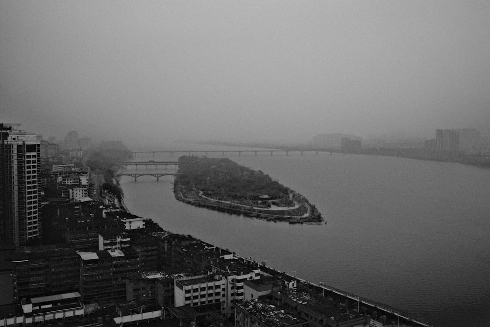 a black and white photo of a river and a bridge