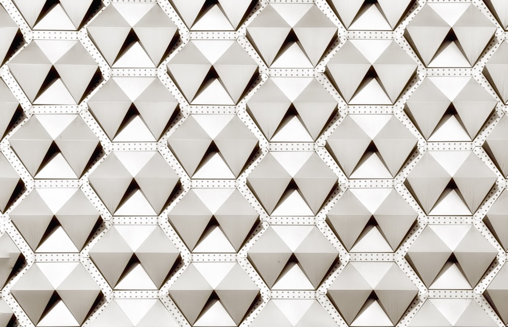 a black and white photo of a wall made up of triangles
