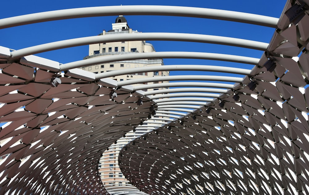 a large metal structure with a clock tower in the background