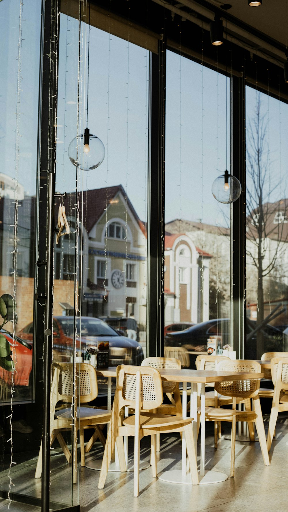 a restaurant with large windows and wooden tables and chairs