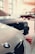 Multiple cars are parked inside a spacious, well-lit garage. The focus is on BMW vehicles, with sleek designs and reflective surfaces. A classic car can be seen in the background, contributing to a vintage atmosphere.