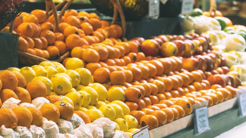 a display of oranges, apples, and other fruits