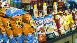 Shelves stocked with a variety of snacks and ready-to-go meals in classic baseball colors.