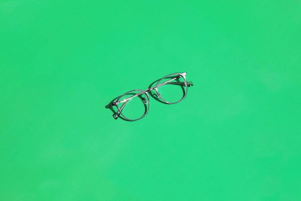 a pair of glasses sitting on top of a green surface