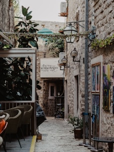 a narrow alley way with tables and chairs