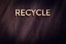 the word recycle written in wood type