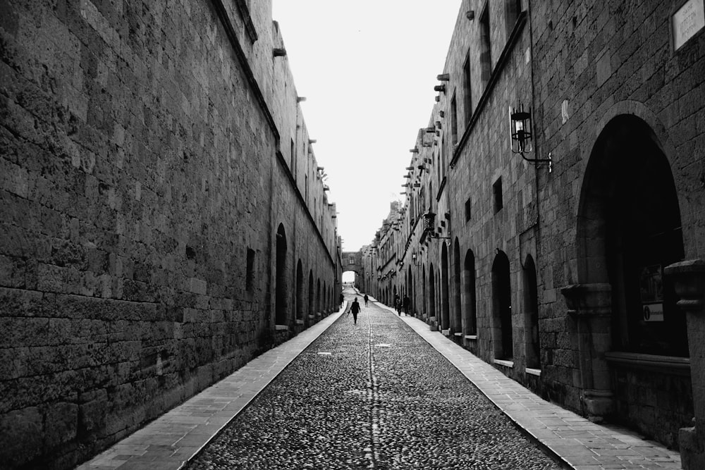 a person walking down an alley way between two buildings