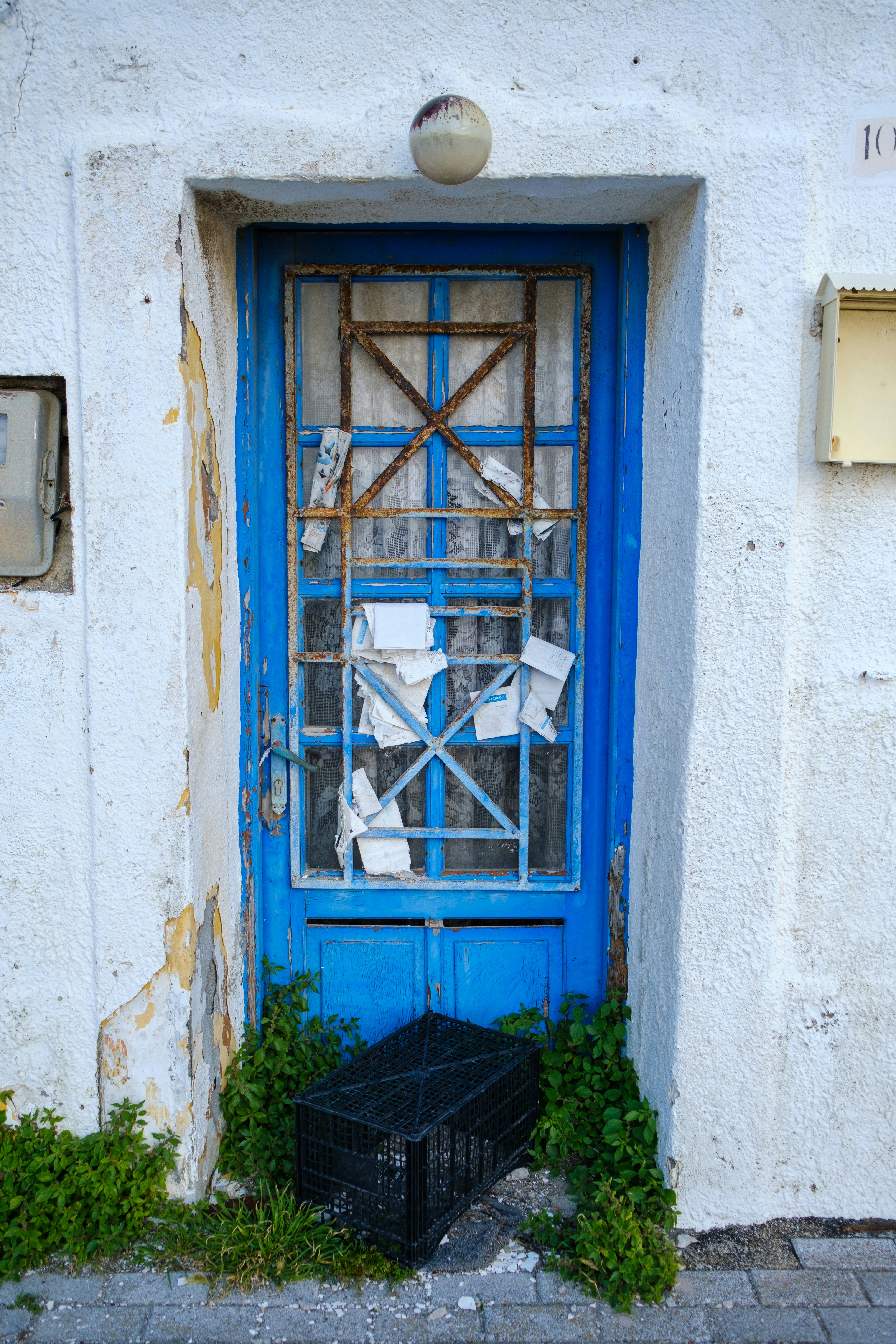 une porte bleue avec une cage devant elle