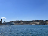 A panoramic view of a cruise ship docked at a bustling Caribbean harbor.