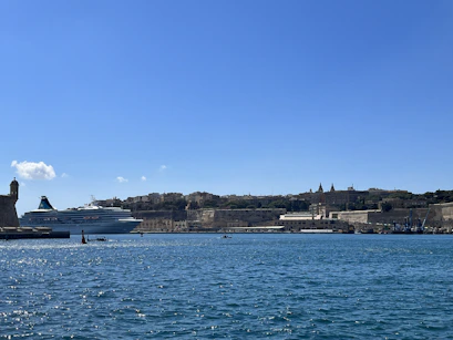 A panoramic view of a cruise ship docked at a bustling Caribbean harbor.