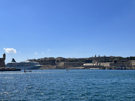 A panoramic view of a cruise ship docked at a bustling Caribbean harbor.