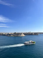 A ferry cutting through sparkling blue waves under a bright, clear sky.