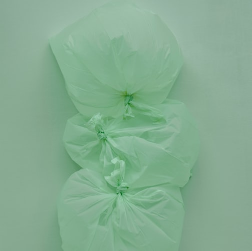 a green bag with three large flowers on top of it